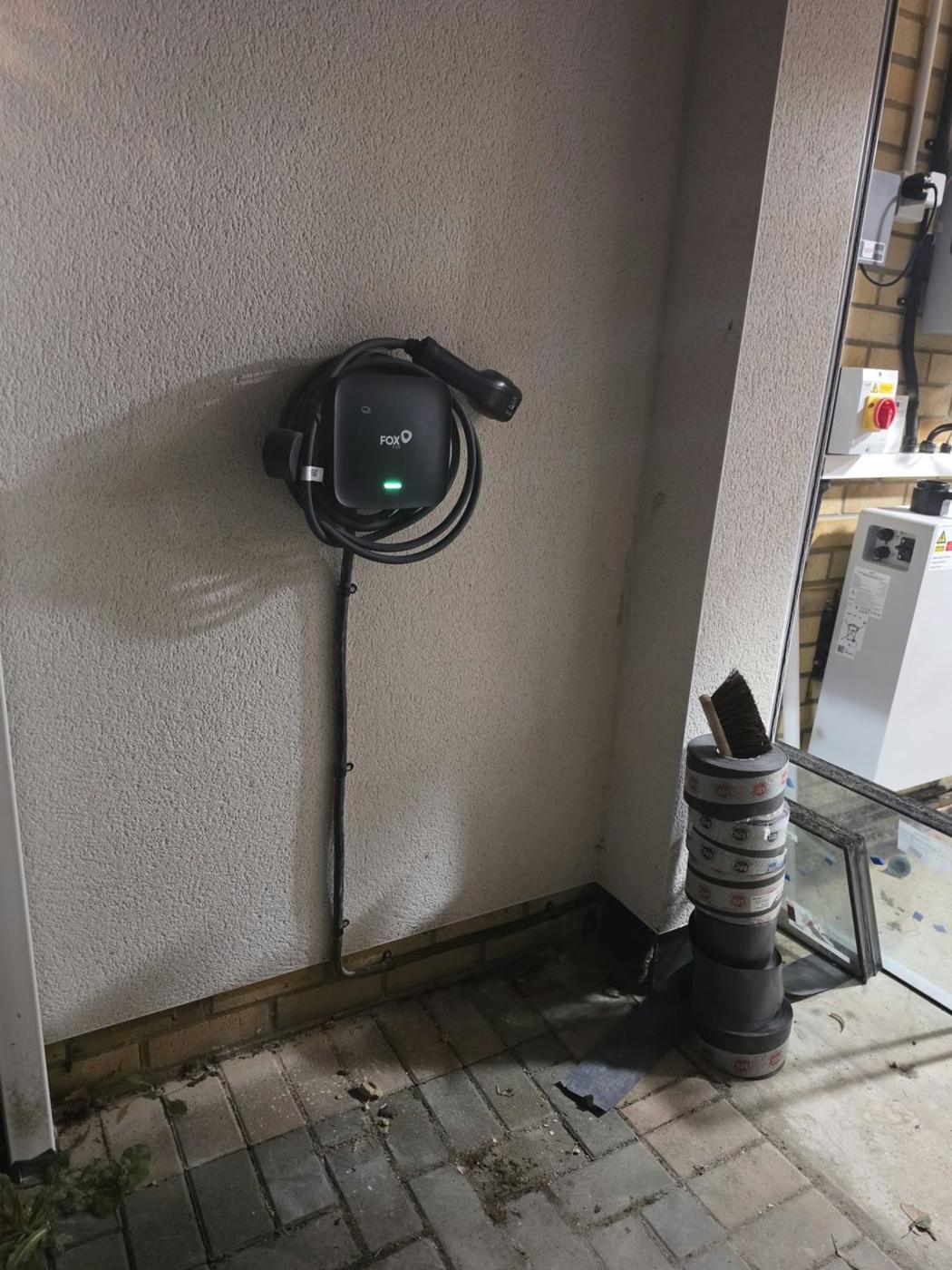 Black EV charger in a covered porch