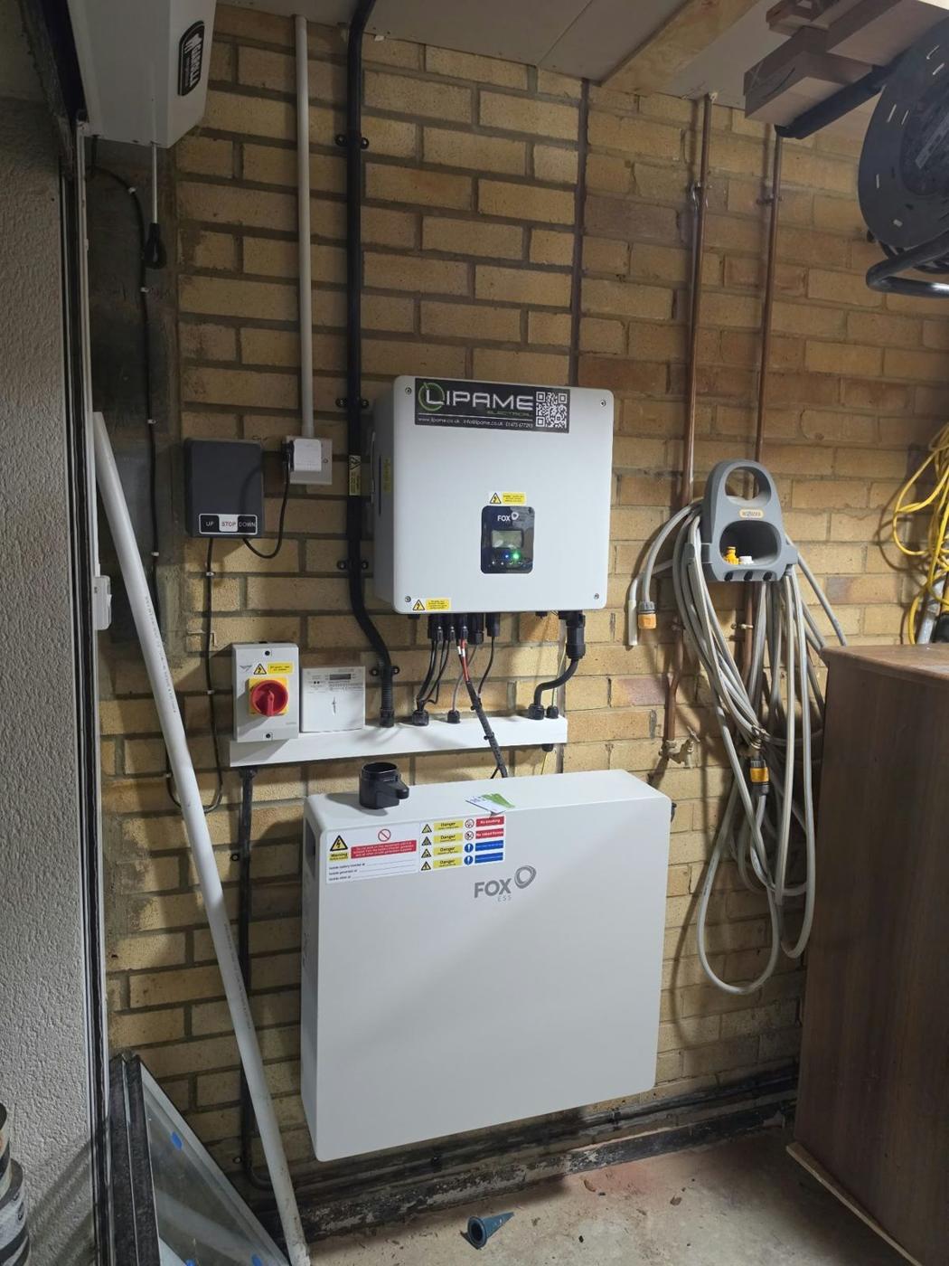 Fox inverter and battery on a garage wall with Lipame label