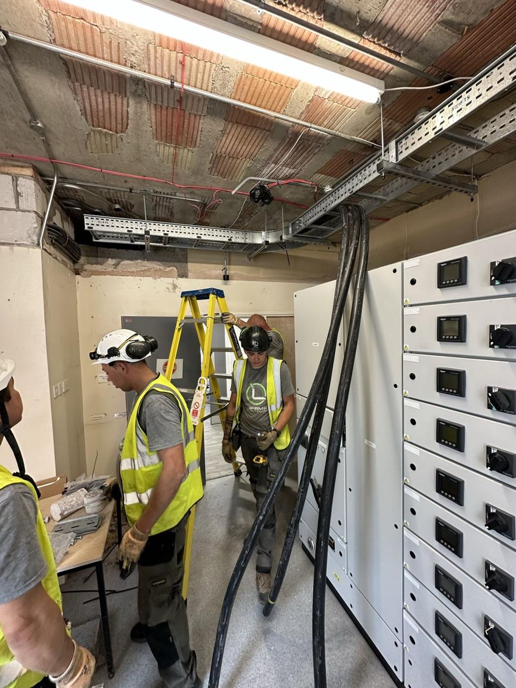 Team fitting cables into a switch panel