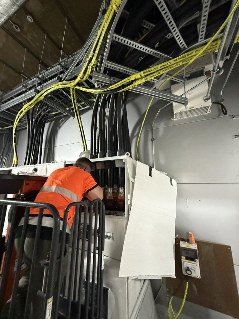 Engineer dressing cables in a busy plant room