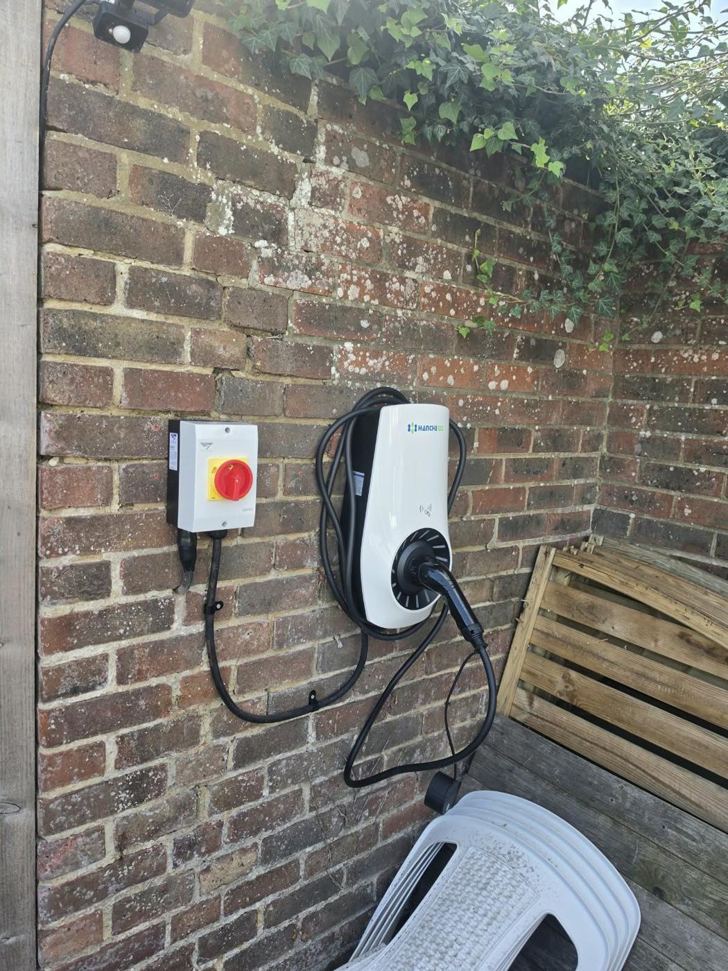 Smart EV charger with isolator on a brick wall