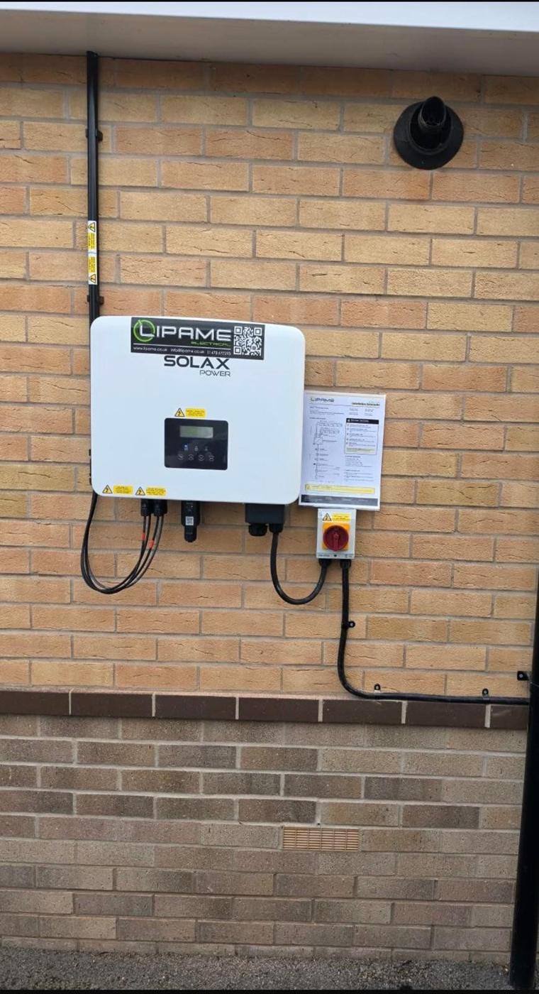 Hybrid inverter with Lipame sticker, AC isolator and schematic on an outside brick wall