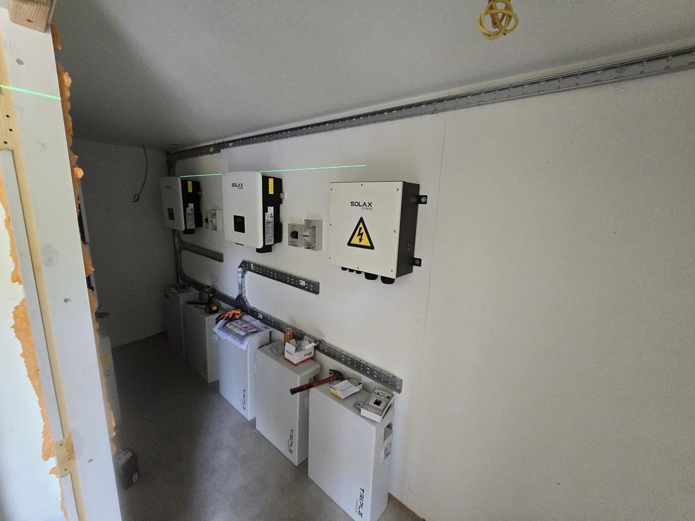 Inverters and batteries being installed along a wall