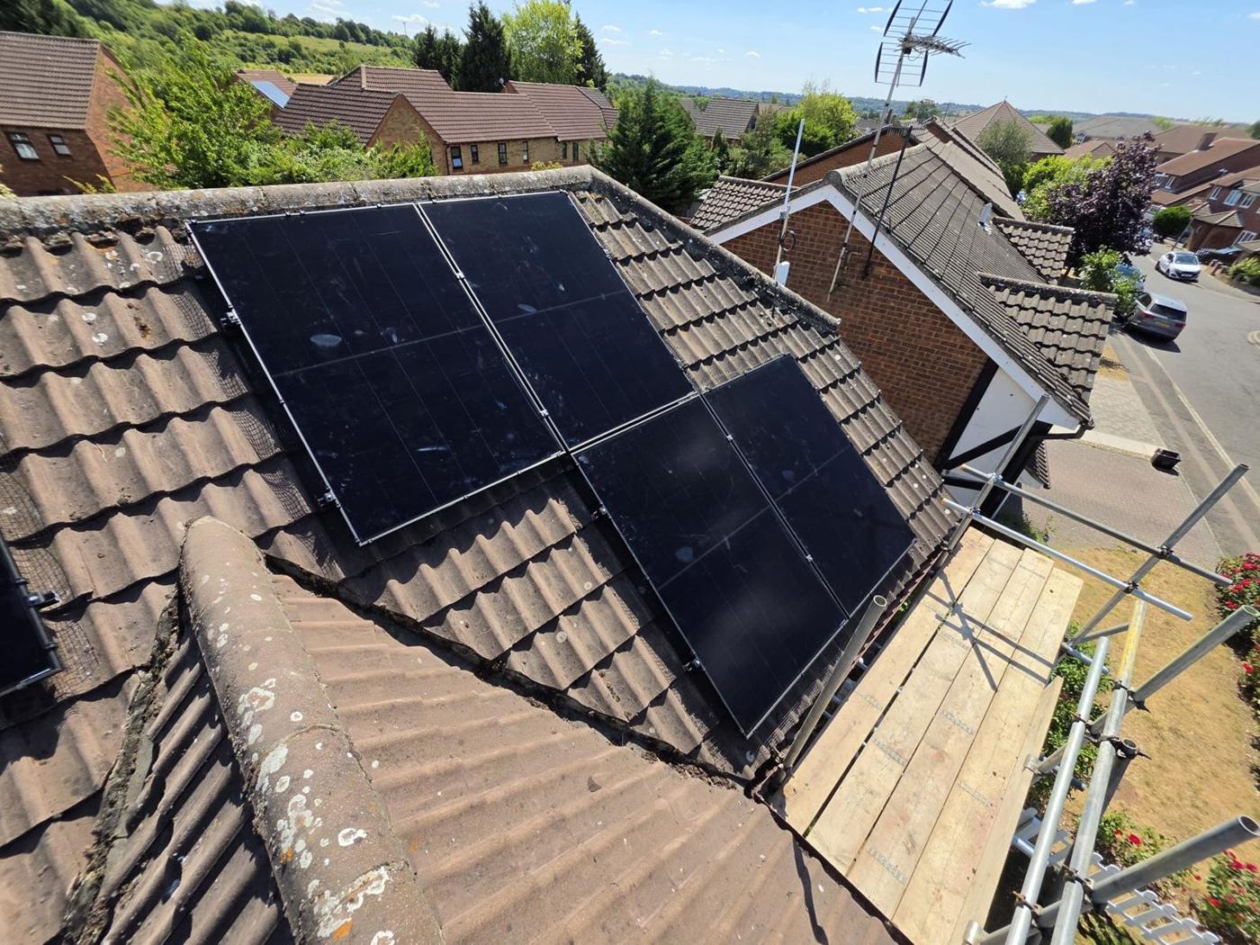 Black panels on a hipped tiled roof
