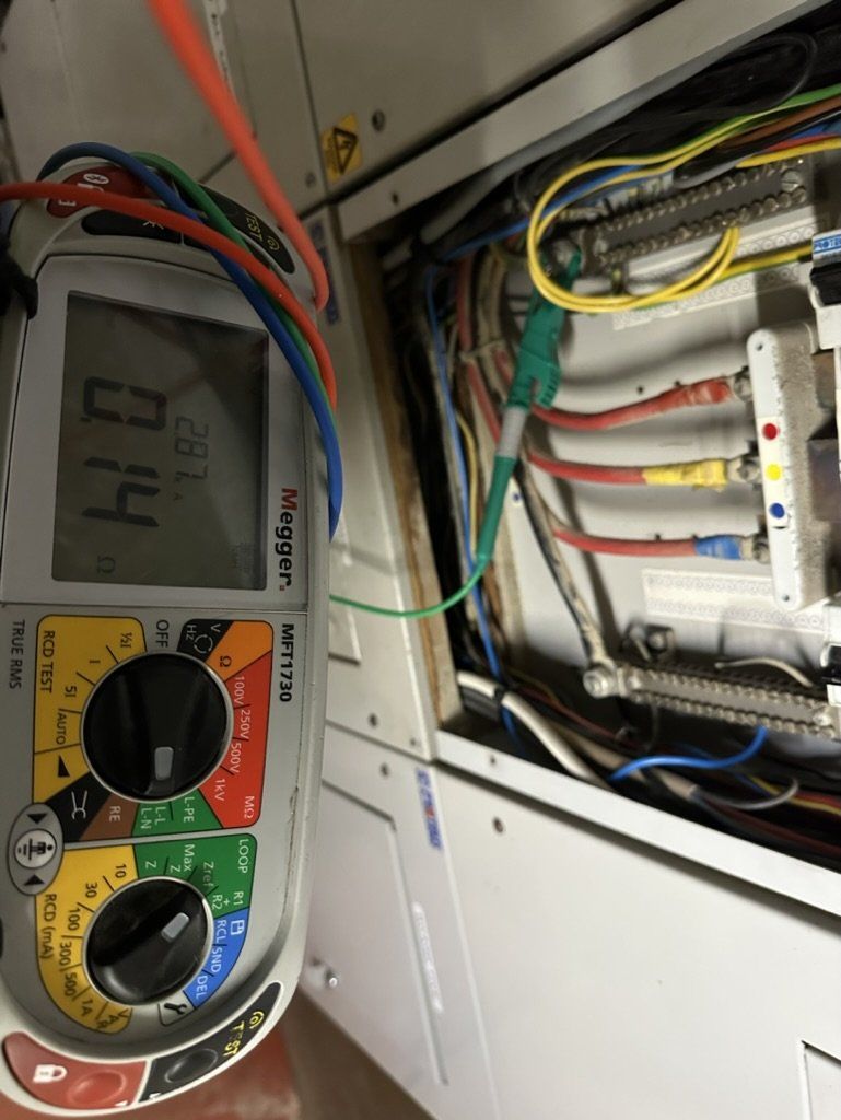 Tester beside an open consumer unit