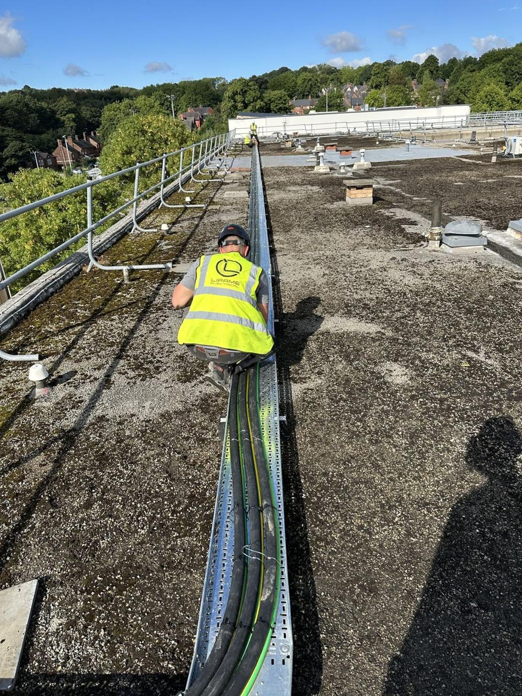 Lipame electrician laying SWA cables into rooftop tray