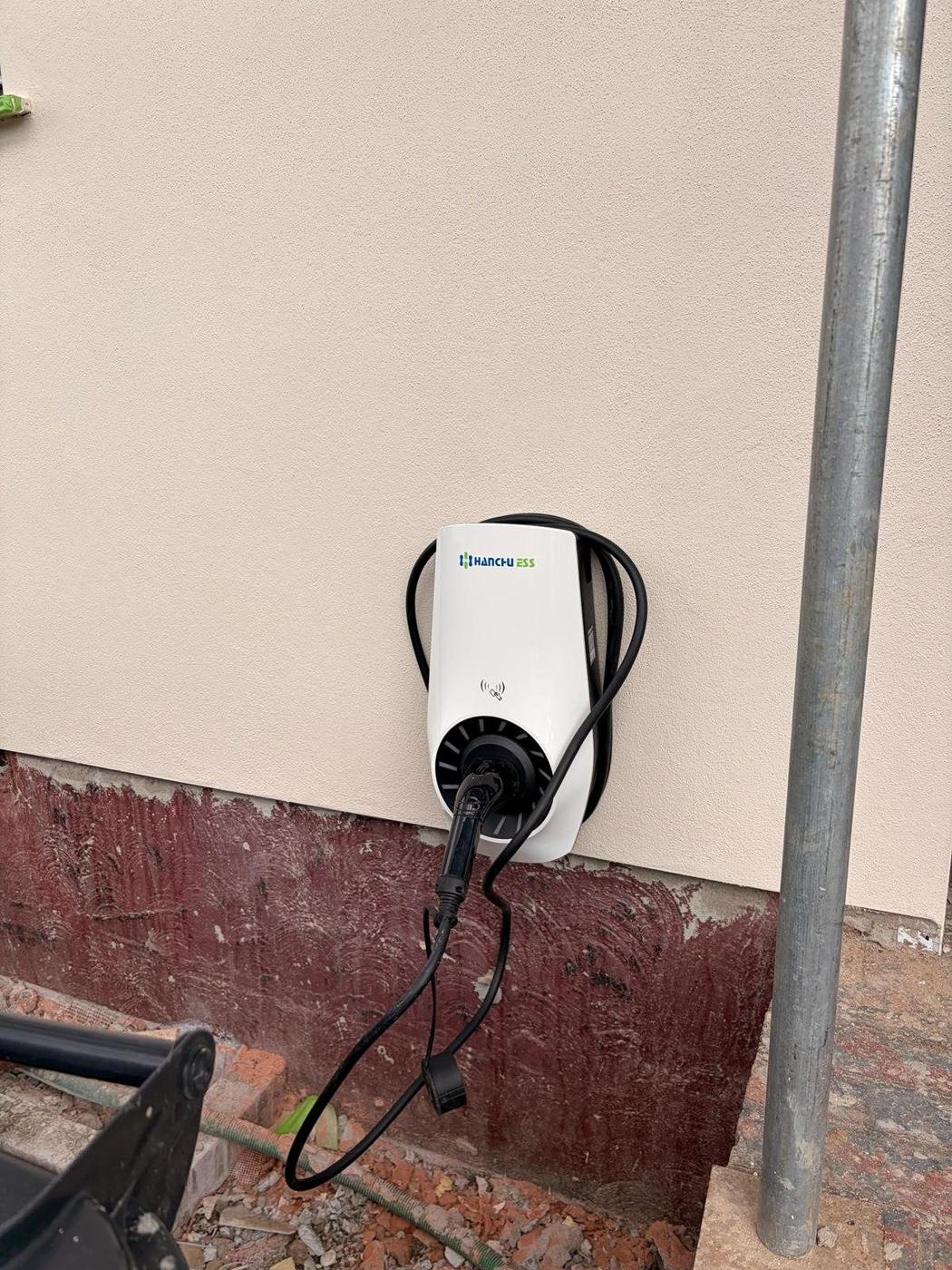 White EV charger on a rendered wall