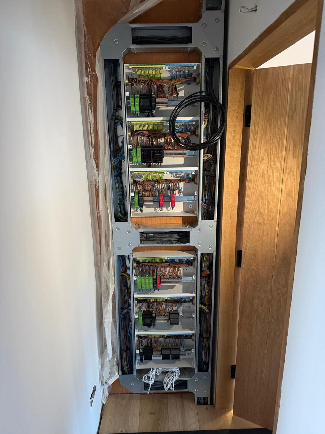 Tall smart house control board built into the wall, fully wired with Shelly Pro modules