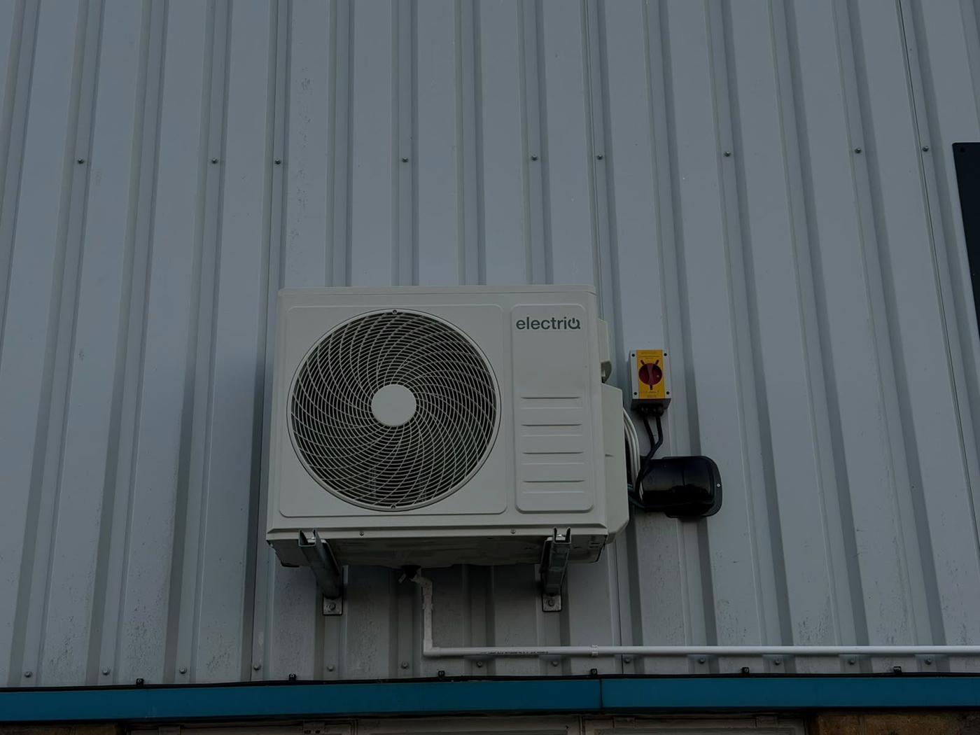 AC outdoor unit on wall brackets with isolator