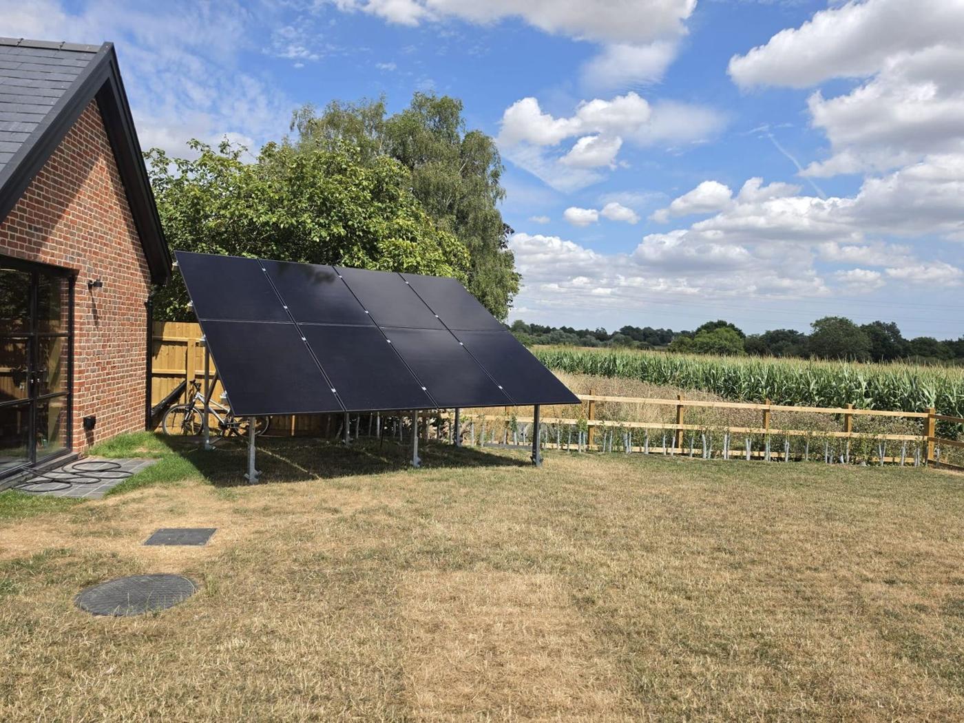 Ground-mounted solar array beside a new home