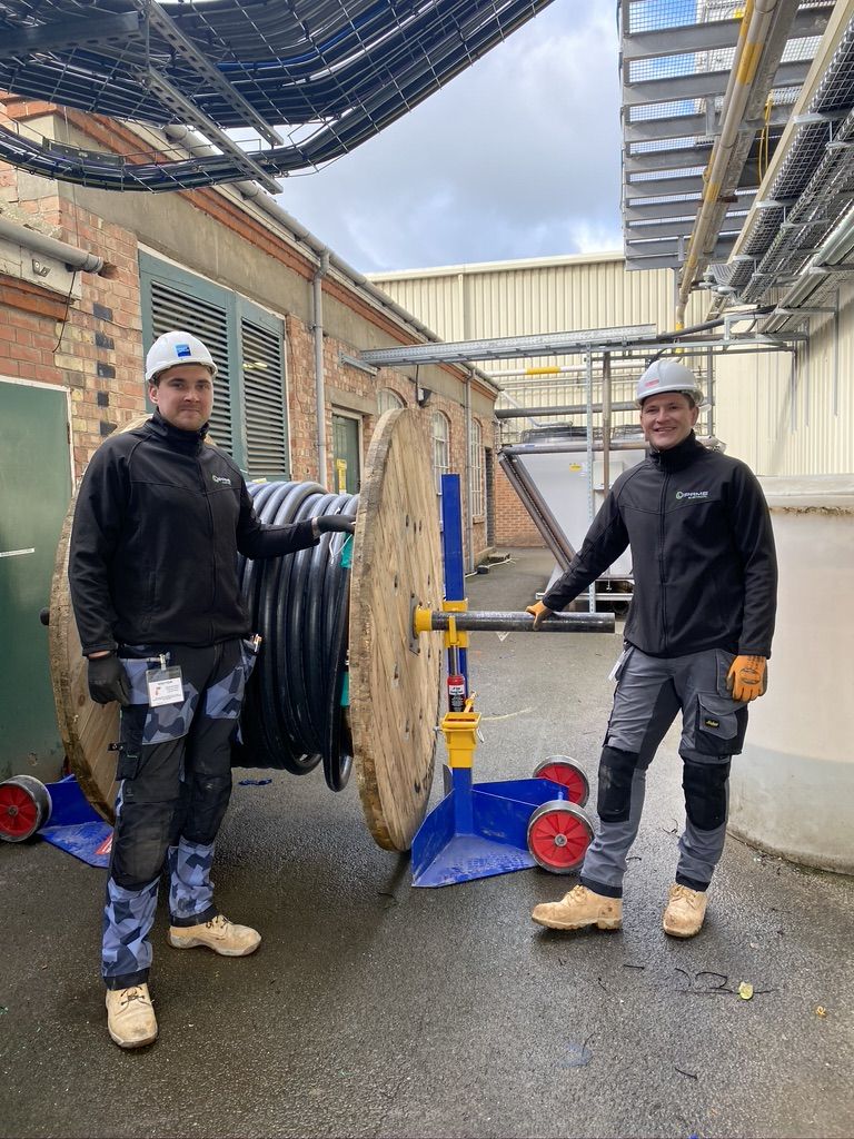 Two Lipame electricians with a cable drum on site