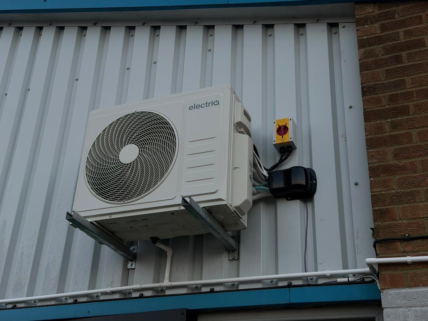 AC outdoor unit mounted high on cladding