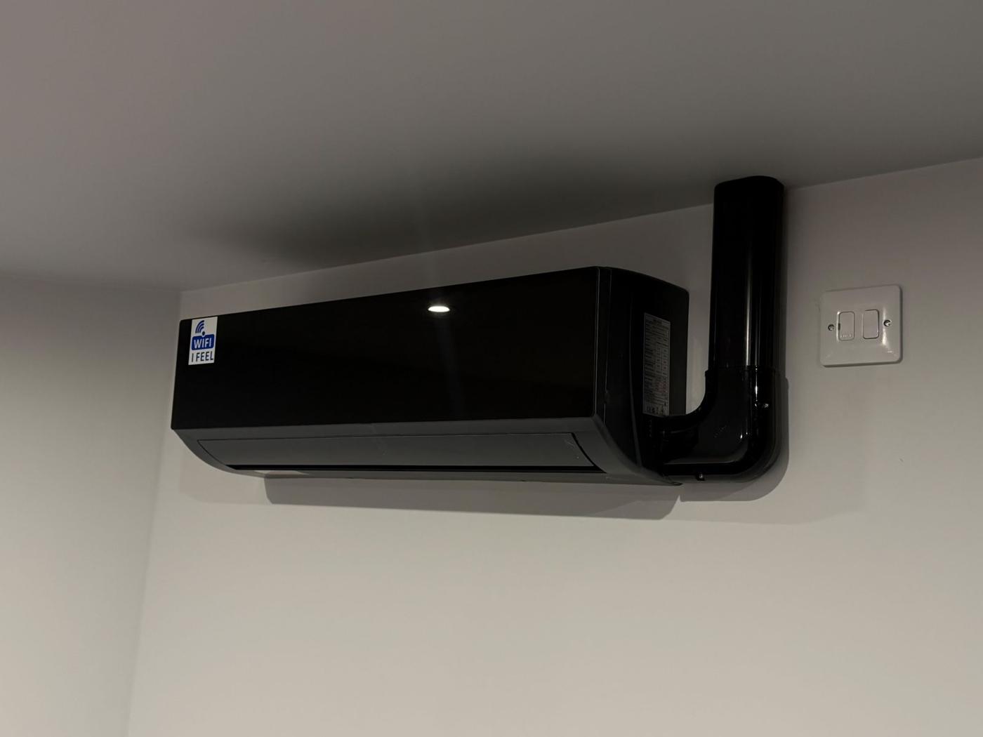 Black split AC indoor unit with neat pipe cover