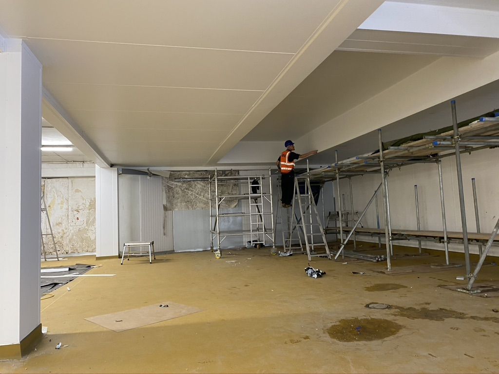 Engineer fitting containment high in the factory hall